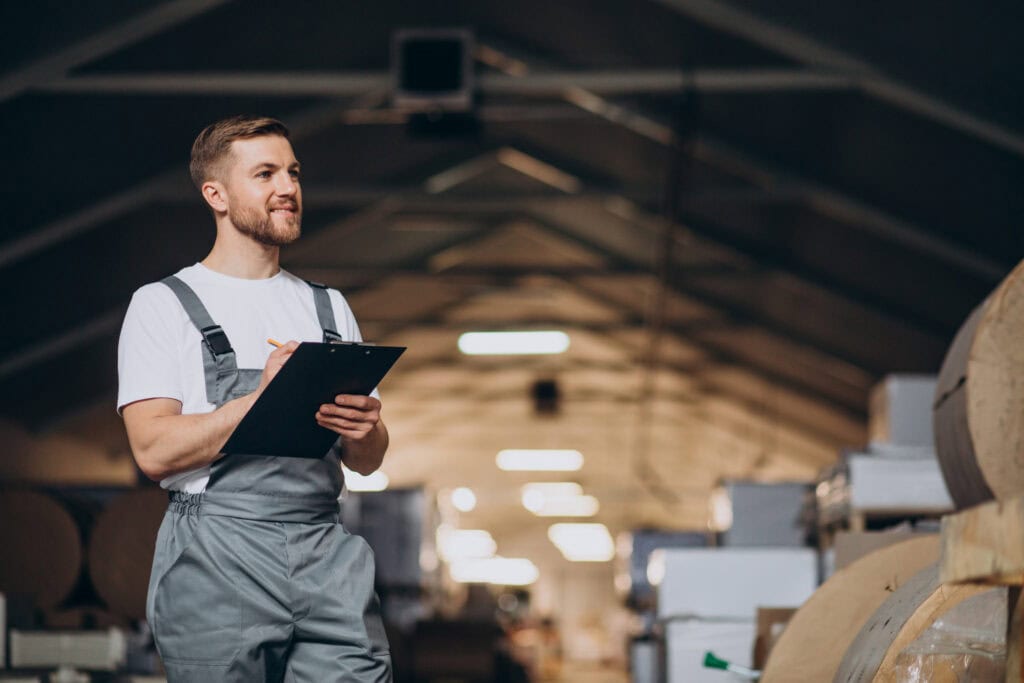 Young man holding a clipboard working at a factory