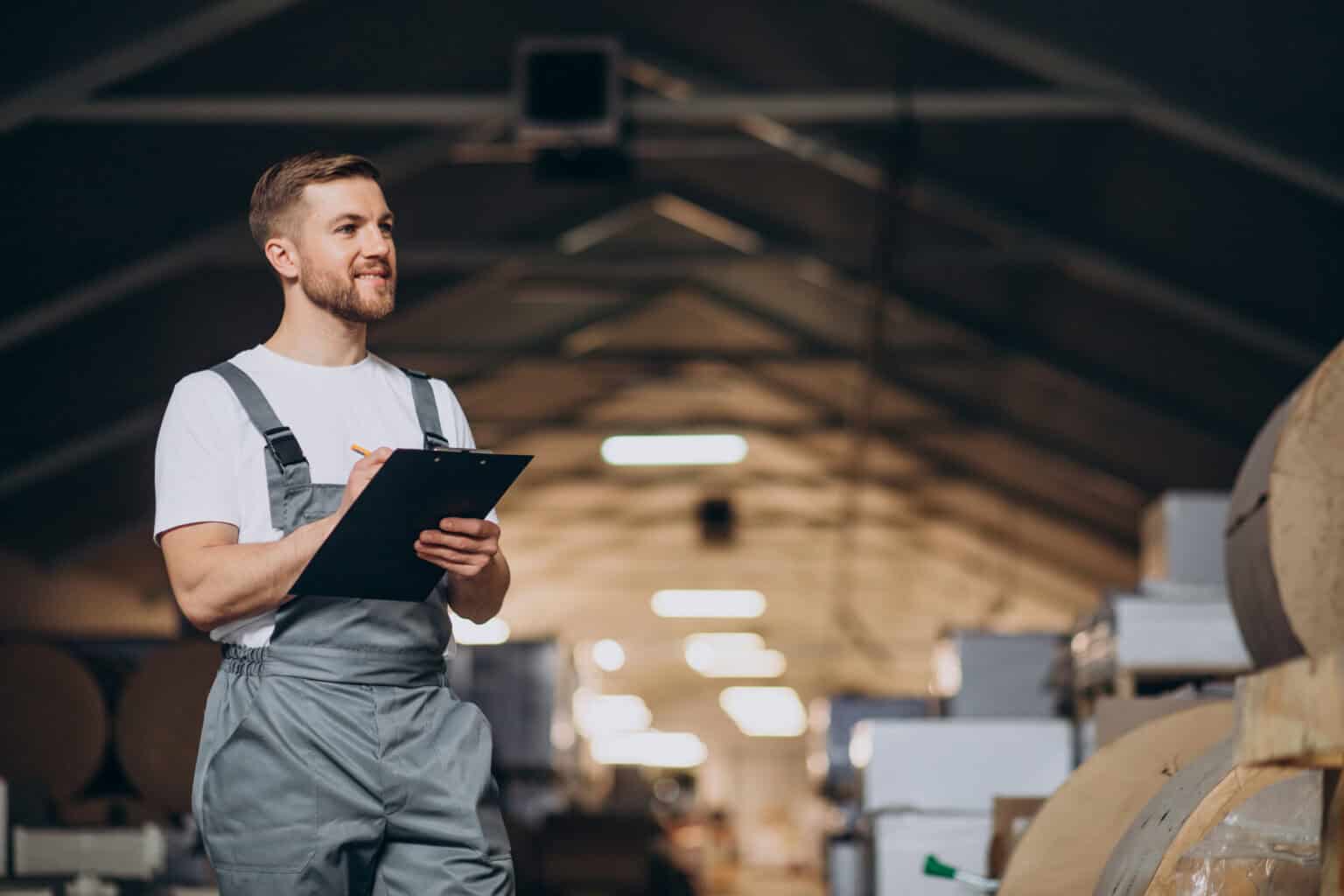 Young man holding a clipboard working at a factory