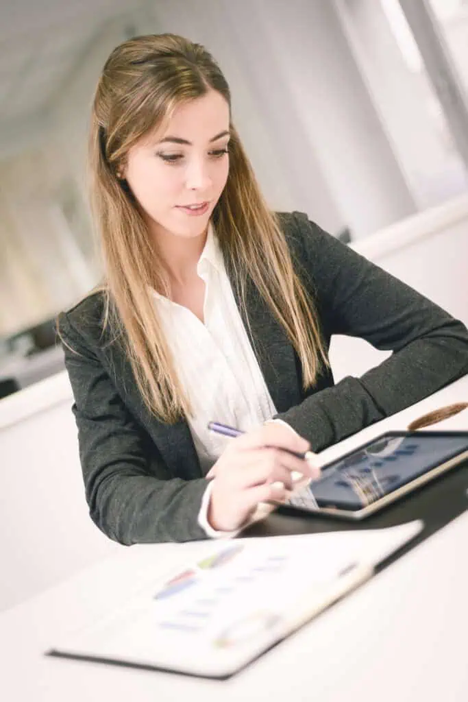 Woman working in finance management is looking at the reports on her tablet