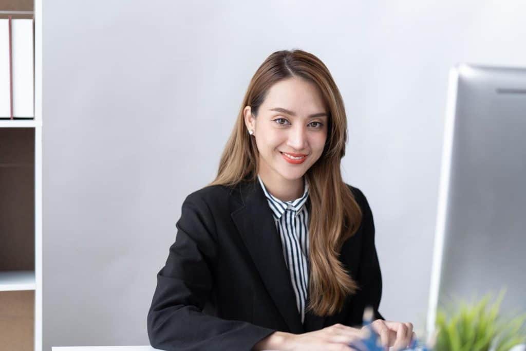 Interim marketing specialist sitting at her desk and working with smile