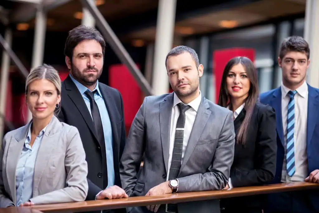 Group of multi ethnic business people standing together leaning against rail