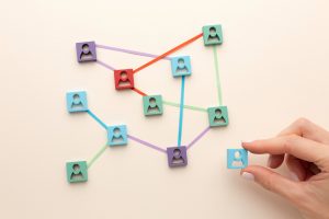 Supplier segmentation show on cardboard by a hand arranging little avatars connected divided by colors